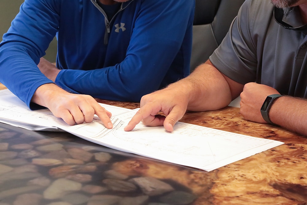 A close up of two Northern Plains Railroad employees pointing at a paper in a conference room