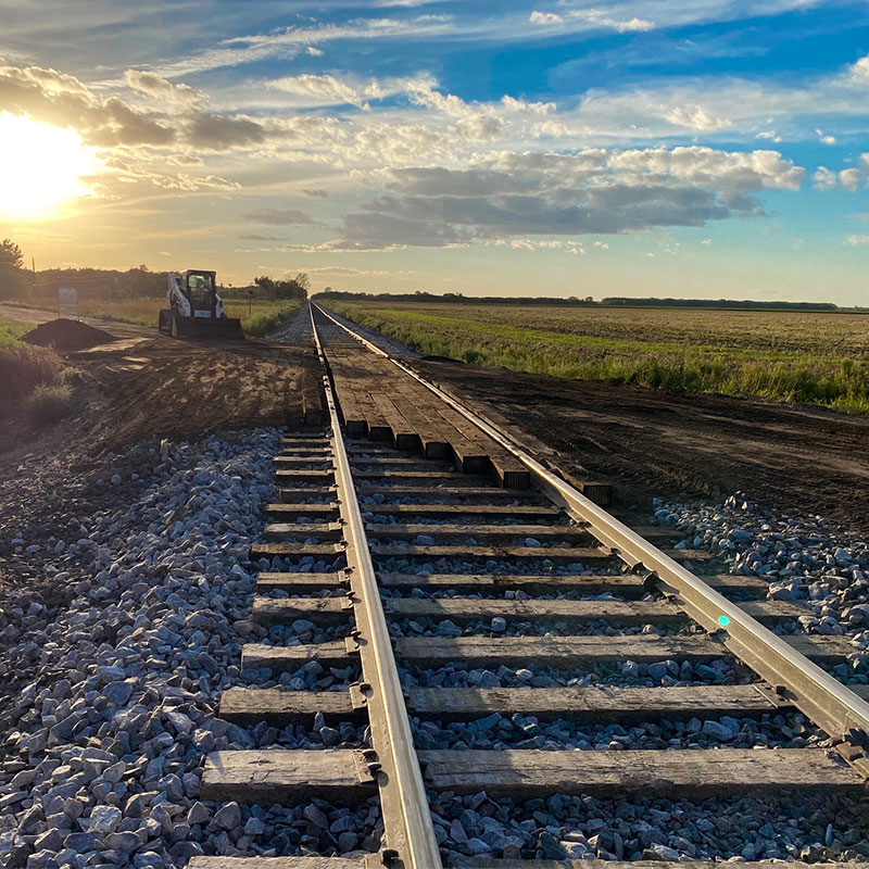 A scenic image of train tracks at sunset