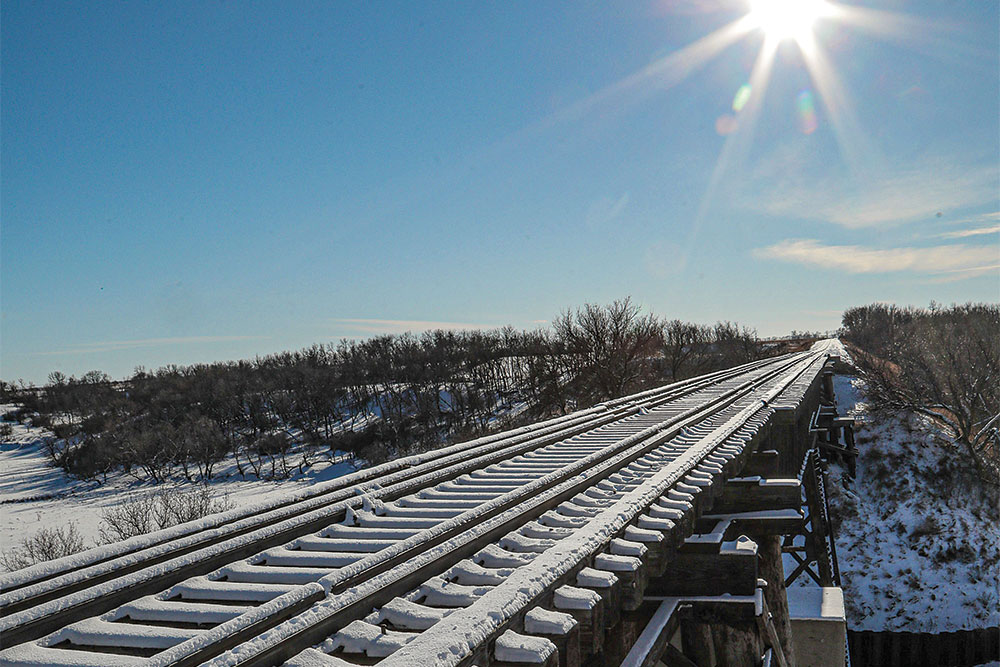 A scenic photo of a snow-covered railroad bridge in Devils Lake, ND