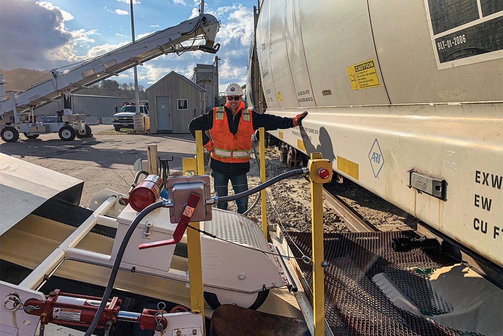 A Northern Plains Railroad employee transloading a train car.